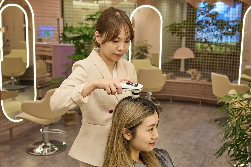 A TrichoLab therapist performing the Signature Medical Microneedling Hair Growth treatment in the boutique