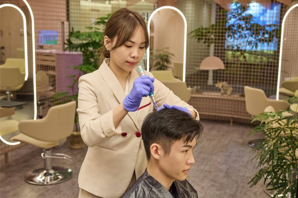 A TrichoLab therapist performing the Signature Medical Microneedling Hair Growth treatment in the boutique