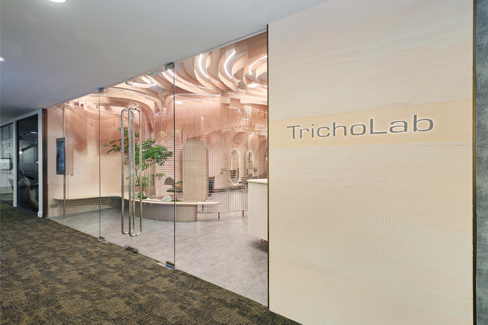 TrichoLab boutique exterior with glass frontage, warm plant-filled treatment rooms visible inside
